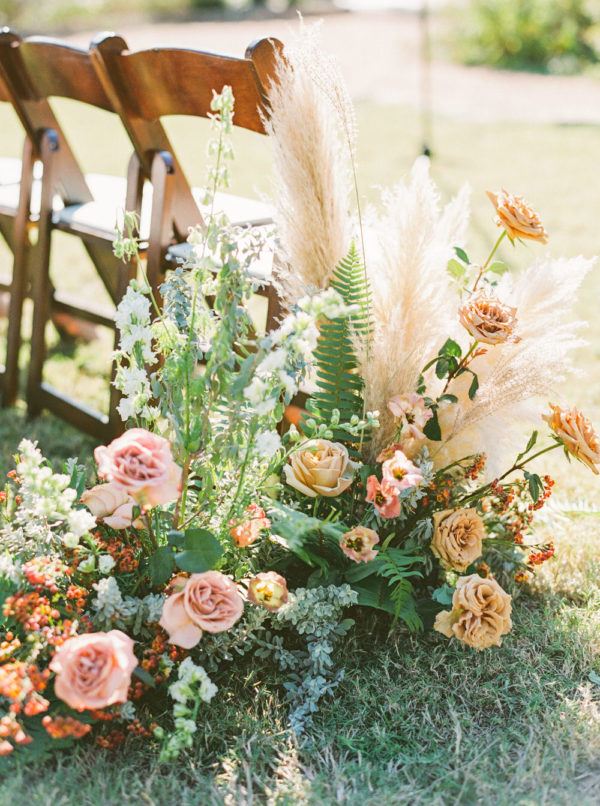 pampas grass and rose installations line the ceremony aisle in Texas