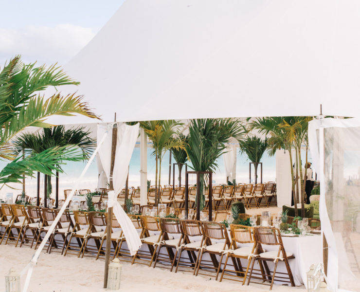 tented wedding reception with greenery decor and bamboo chair