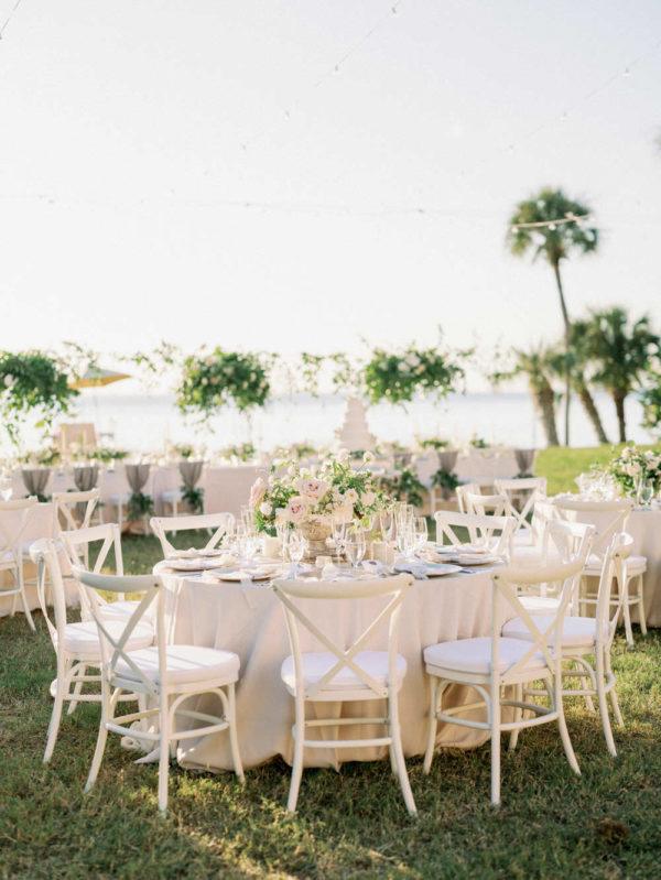 white wooden chairs and neutral floral centerpieces at the Florida reception