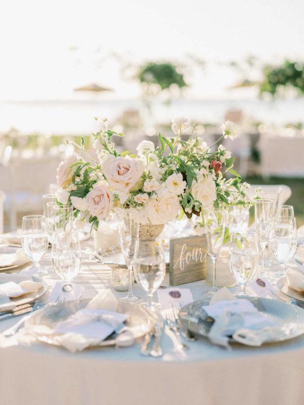 pink and cream colored roses in the lush centerpiece and wooden table number