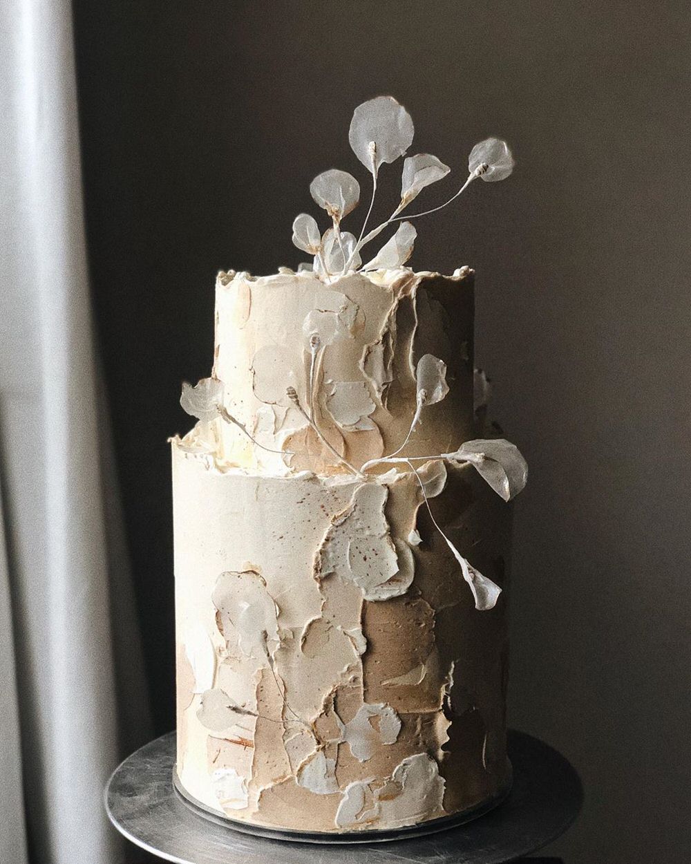 mismatched two tiered cream cake with translucent leaf details