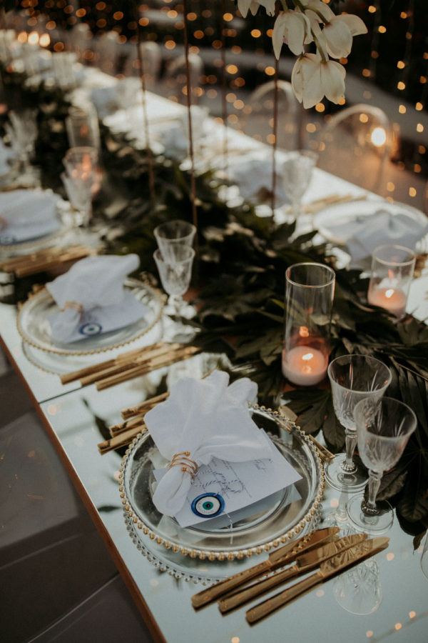 Santorini wedding favors and lush green runner on the reception table