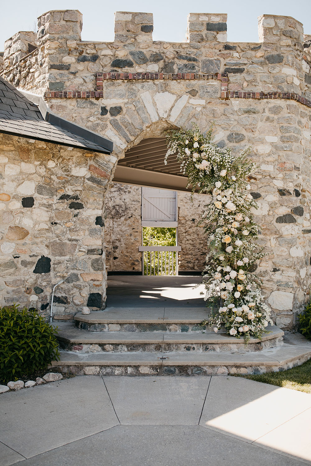 Michigan chateau wedding venue with climbing florals on an old stone wall