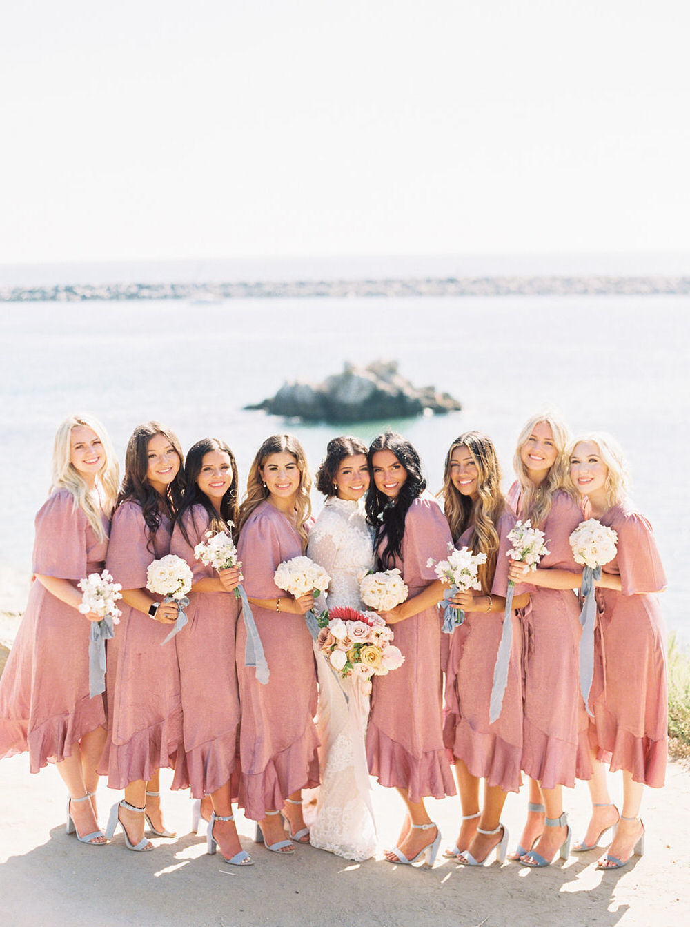 bride with her bridesmaids in peachy dresses