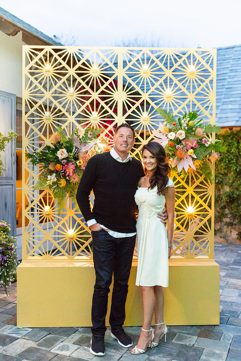 soon to be bride and groom with sunny photo wall