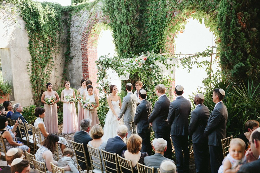 courtyard wedding ceremony with greenery chuppah