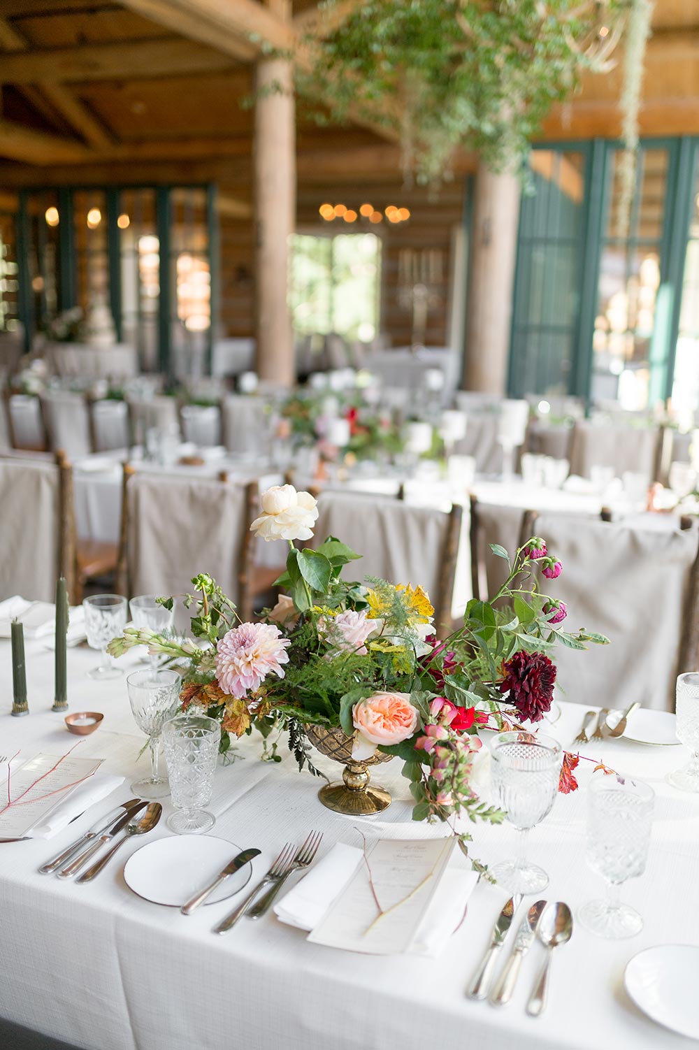 romantic cabin wedding reception decor with candles and canvas covered chairs