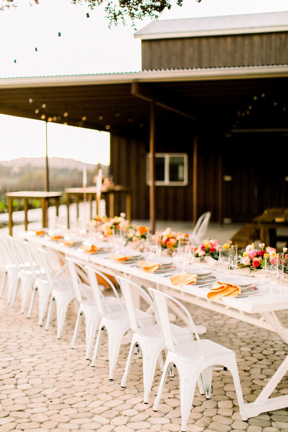 modern vineyard wedding tablescape with all white chairs