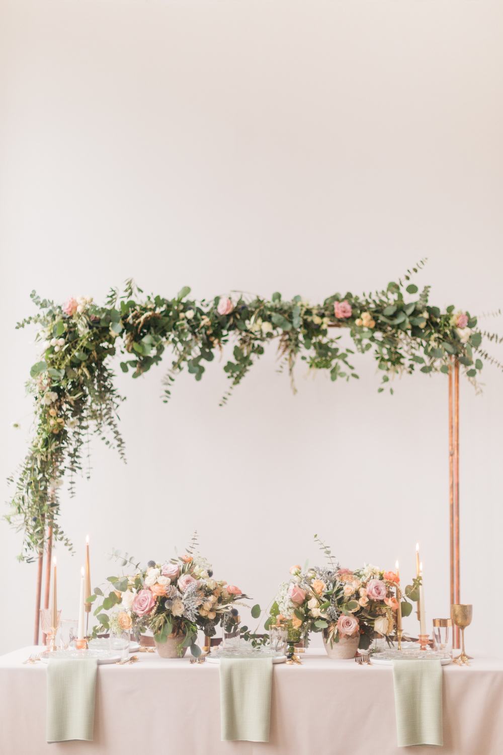 mixed metal greenery arbor and loft wedding tablescape