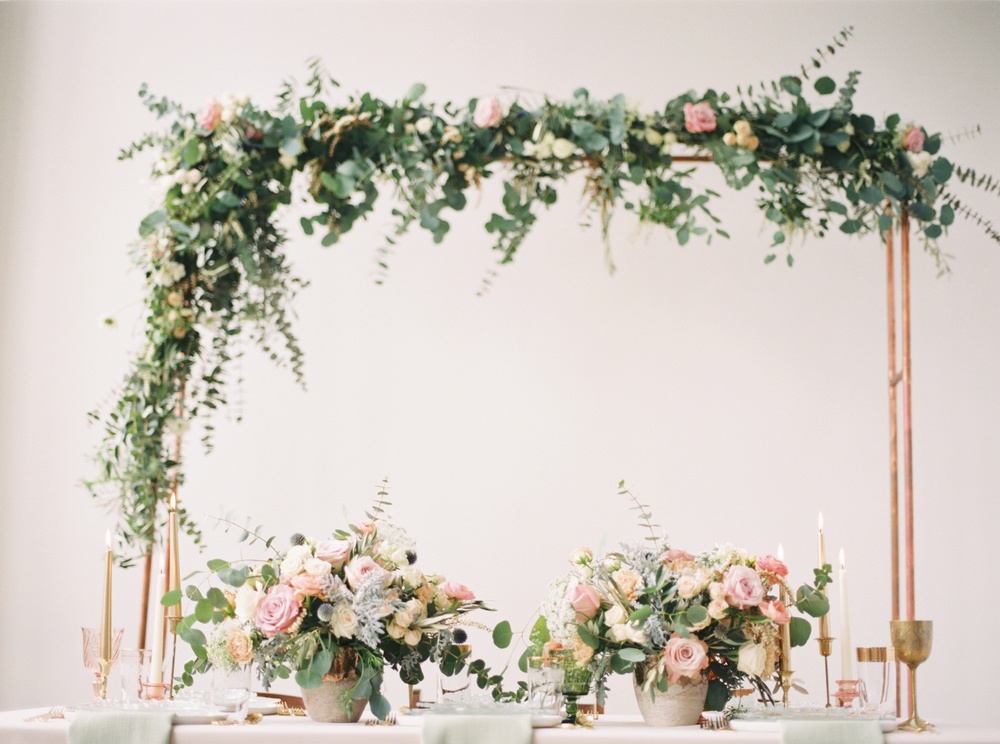 mixed metal greenery arbor and loft wedding tablescape