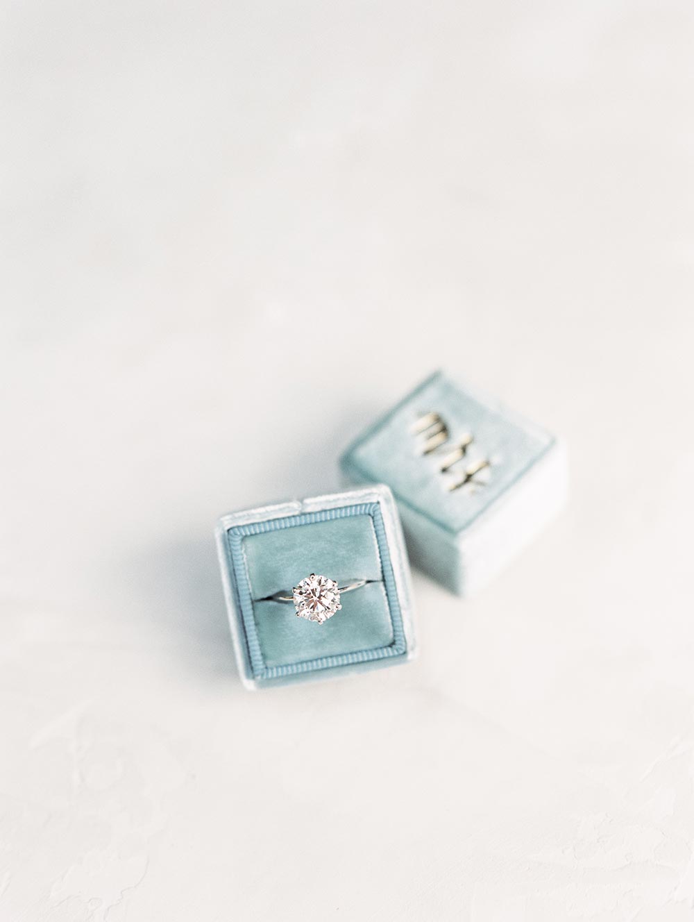 round engagement ring with blue velvet ring box