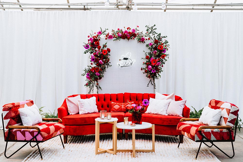 red velvet sofa with shag mid-century chairs for a wedding lounge with neon heart signage