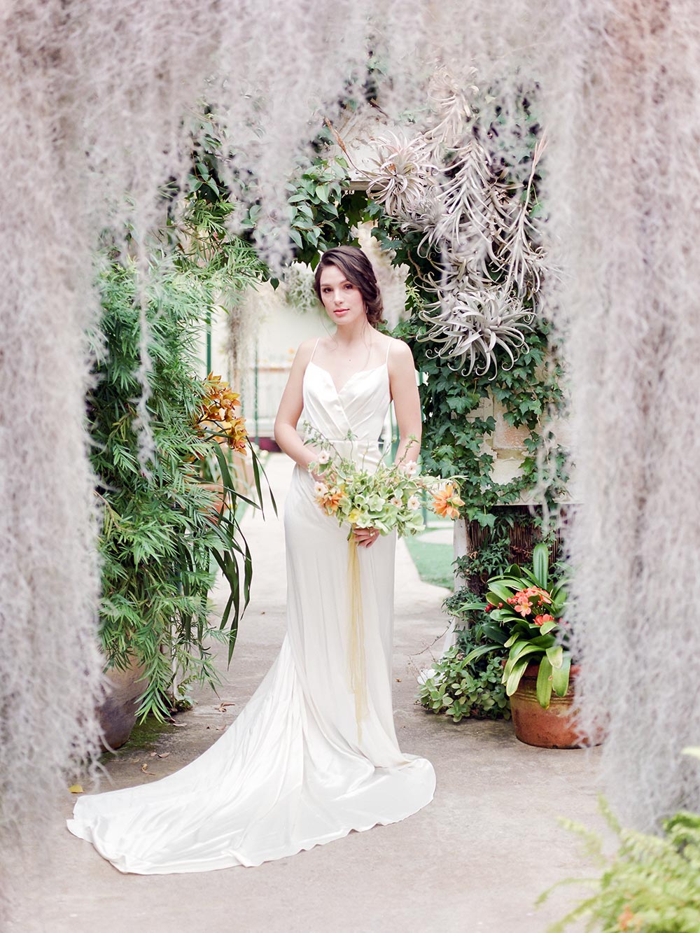 silk wrap wedding dress with organic bridal bouquet in greenhouse reception