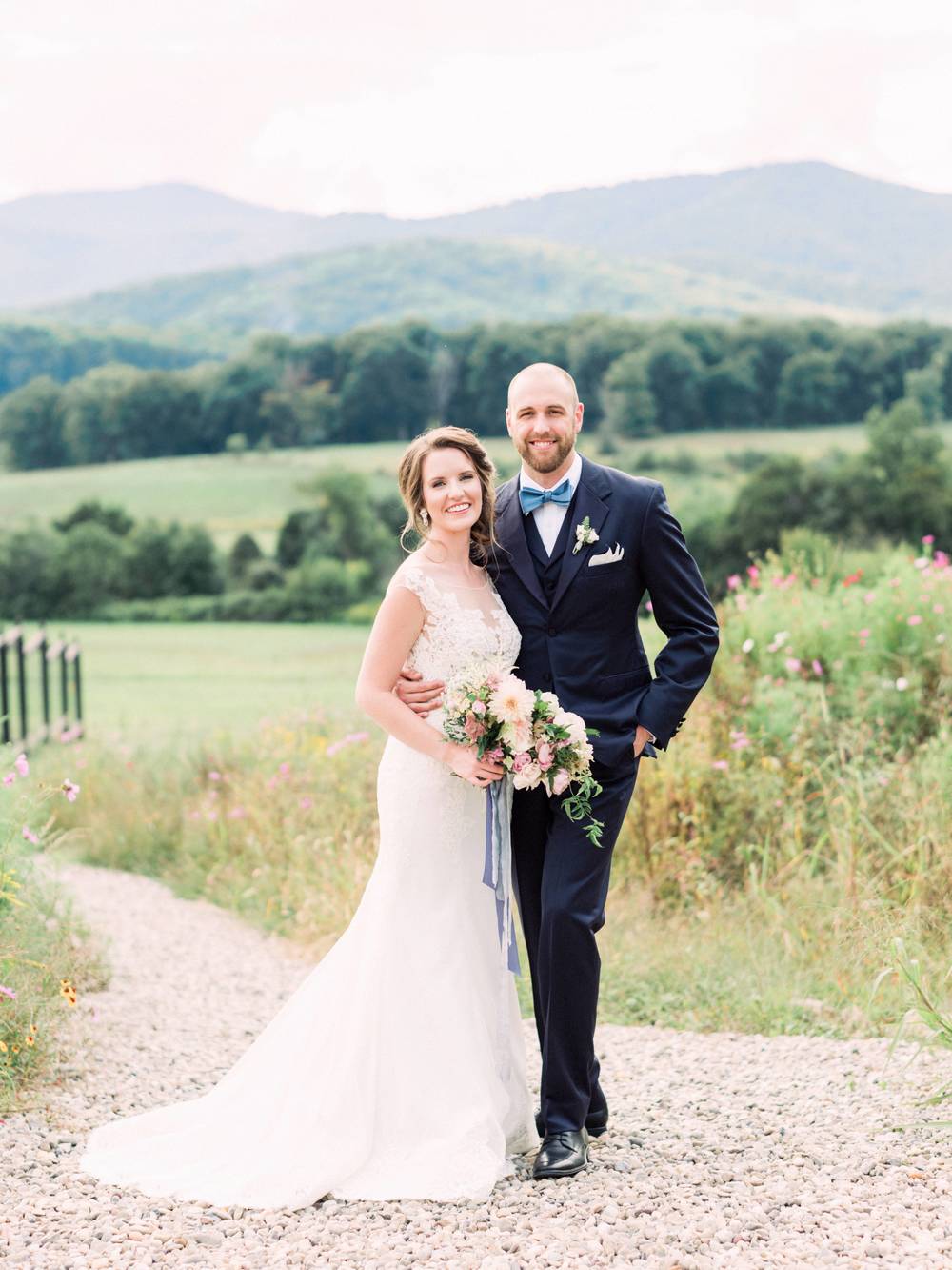 lace wedding dress with veil and navy groom suit