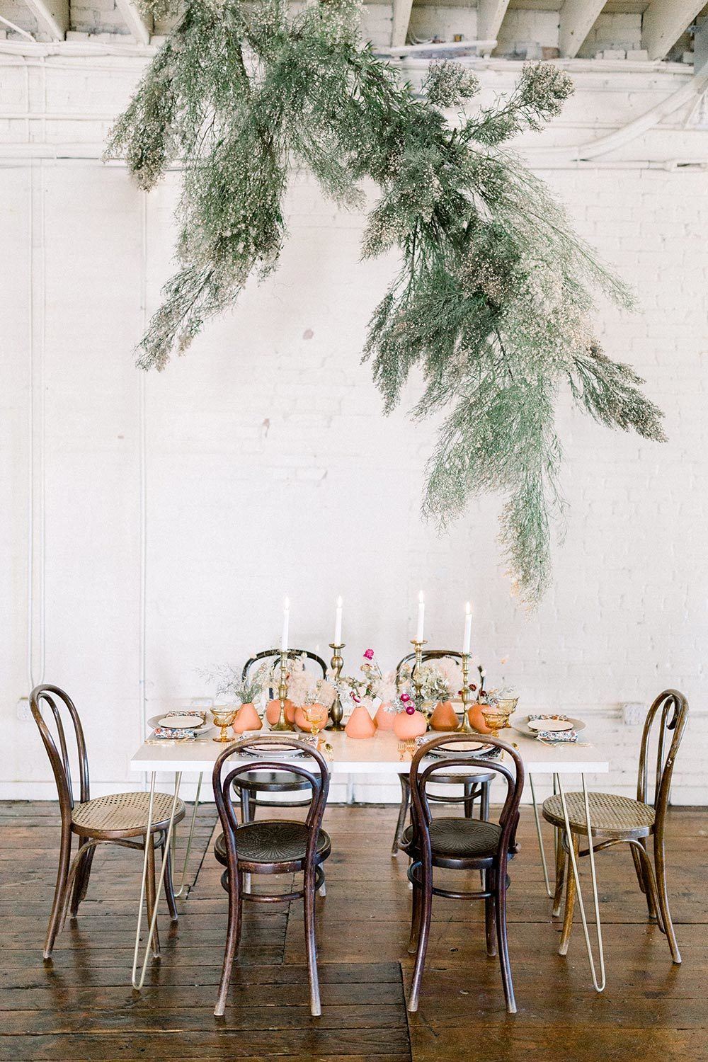 modern earth toned wedding inspiration with greenery floral installation