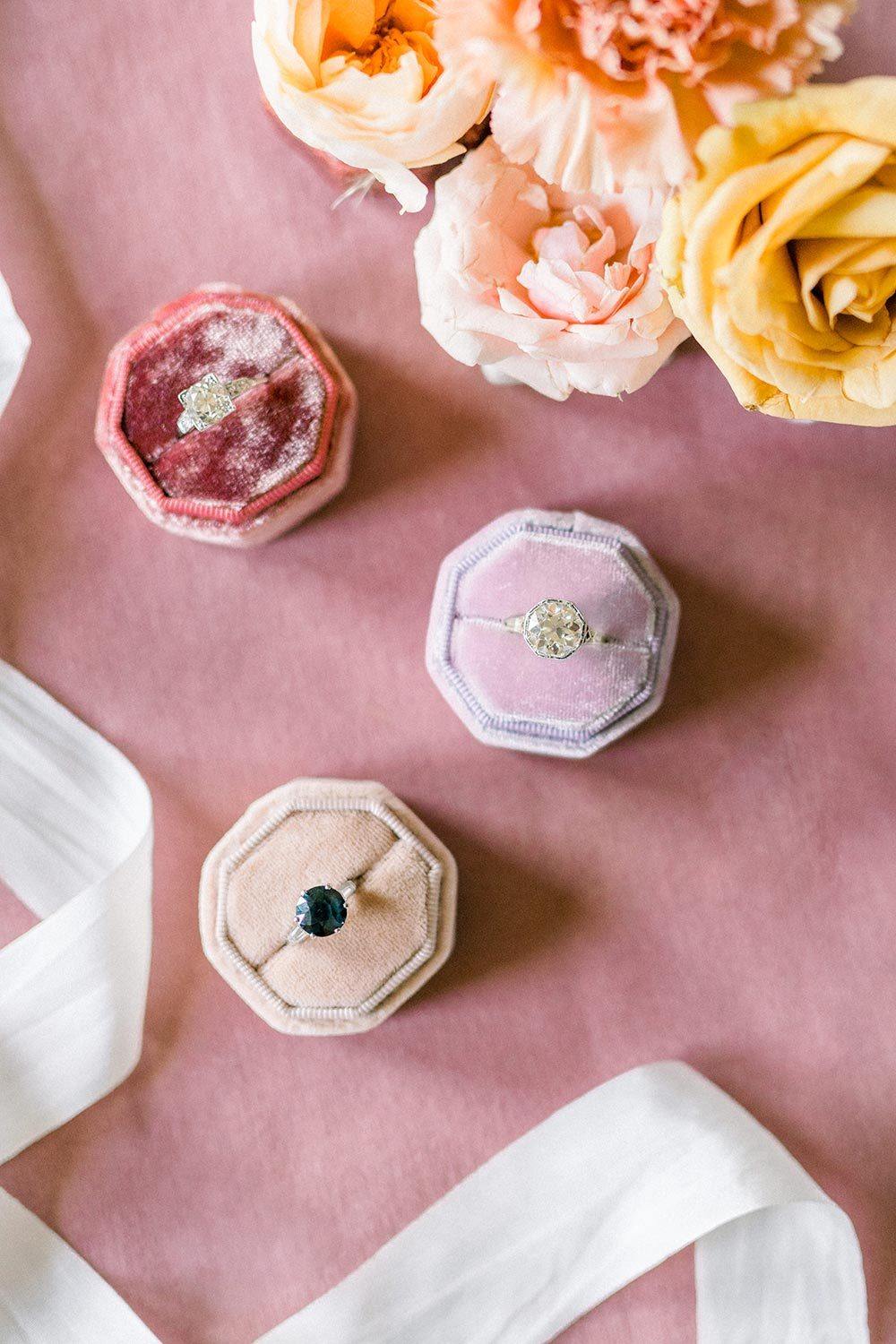 antique engagement rings with velvet ring boxes and fresh flowers
