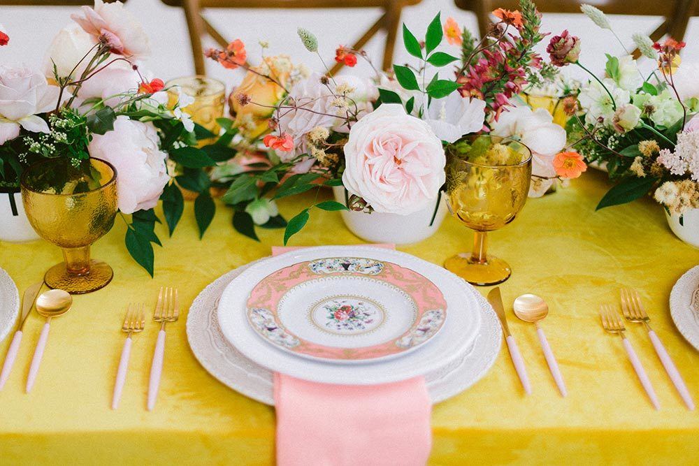 garden flower centerpiece with vintage peach plates and brass candlesticks