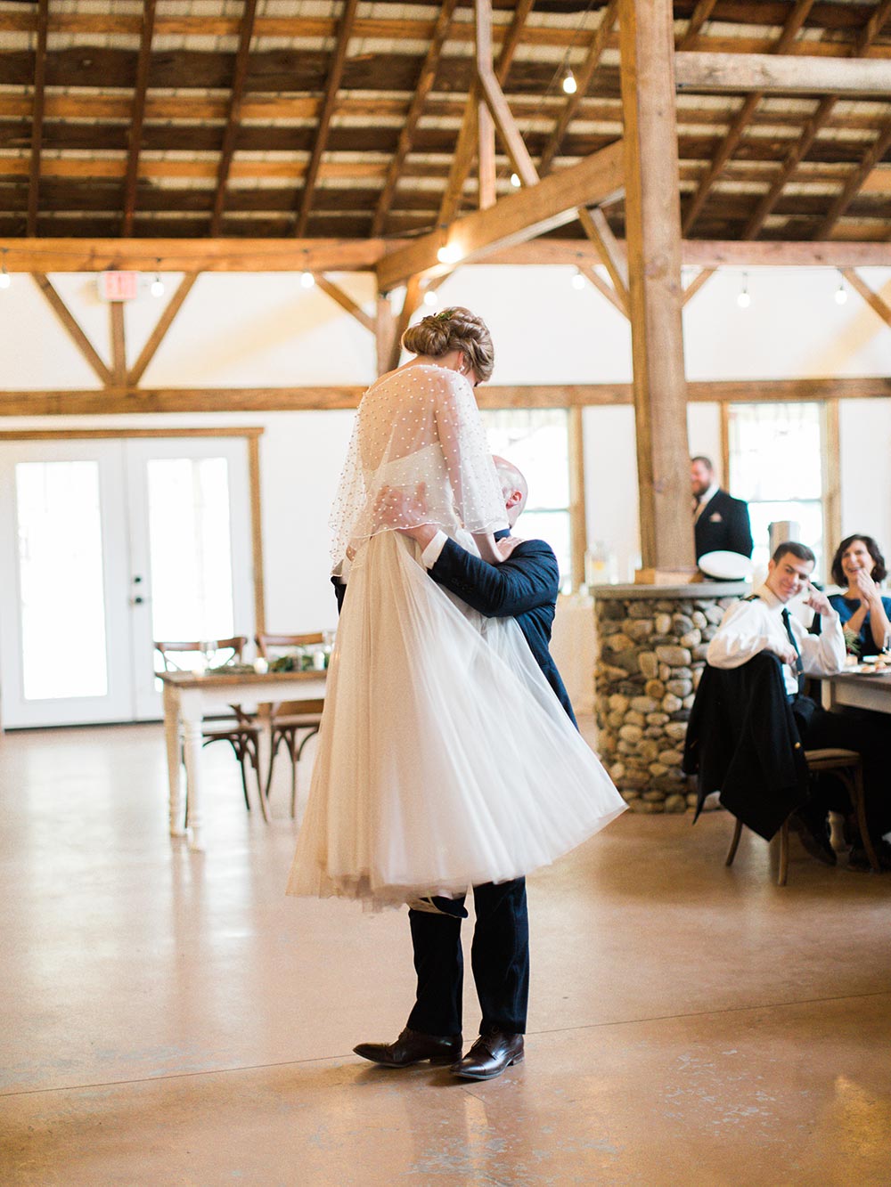 embellished bridal cape and navy groom suit first dance